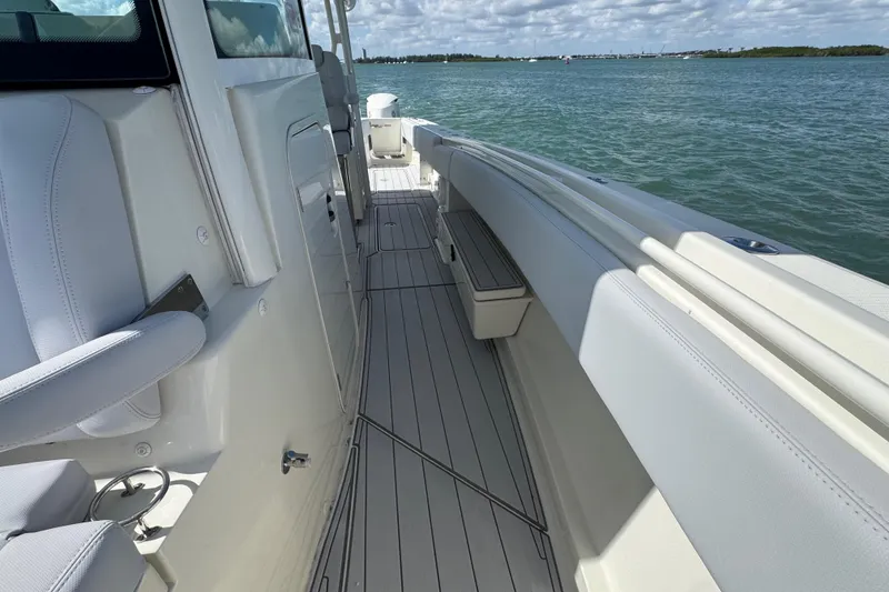 Slide: The Image of 2017 HCB 42 Siesta boat deck with seating, on calm water under a cloudy sky. - 24