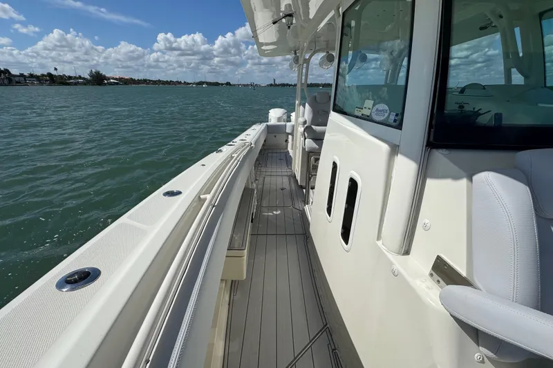 Slide: The Image of 2017 HCB 42 Siesta boat on water, showcasing sleek deck and cabin design. - 25