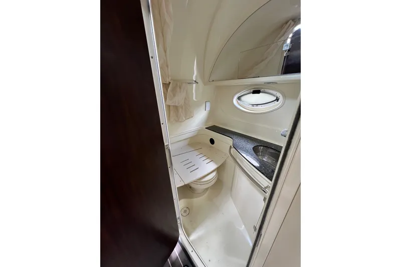 Slide: The Image of 2014 Monterey 320 Sport Yacht bathroom with sink, toilet, and porthole window. - 12