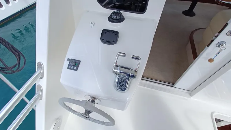 Slide: The Image of 2018 Viking 62 Enclosed Bridge helm station with steering wheel and controls. - 32