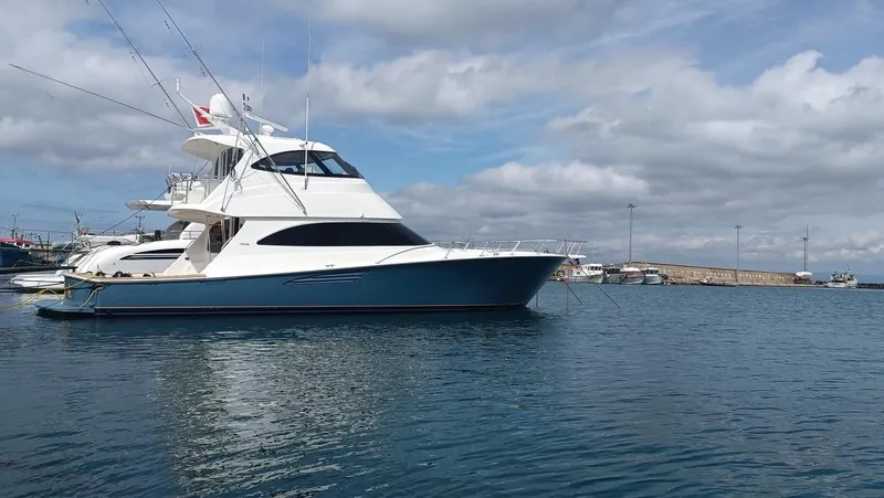 Slide: The Image of 2018 Viking 62 Enclosed Bridge yacht on calm water under cloudy sky. - 46