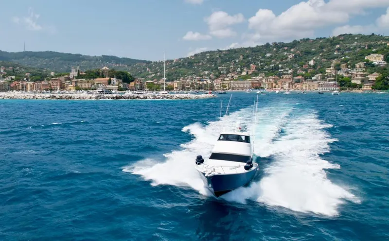 Slide: The Image of 2018 Viking 62 Enclosed Bridge yacht cruising on blue ocean near scenic coastline. - 12