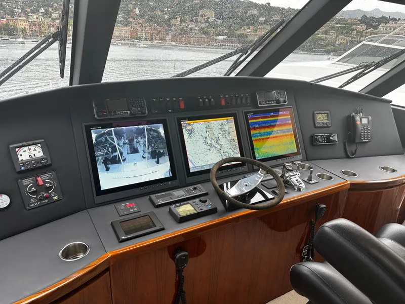 Slide: The Image of Control panel of 2018 Viking 62 Enclosed Bridge yacht with navigation screens and steering wheel. - 20
