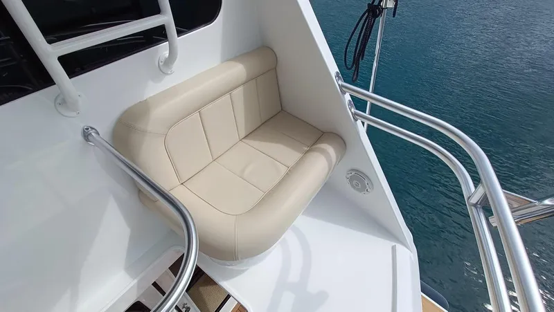 Slide: The Image of 2018 Viking 62 Enclosed Bridge yacht with beige seating and stainless steel railings. - 31