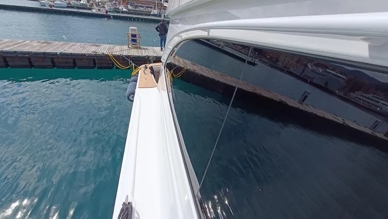 Slide: The Image of 2018 Viking 62 Enclosed Bridge yacht docked at marina, reflecting water and pier. - 37