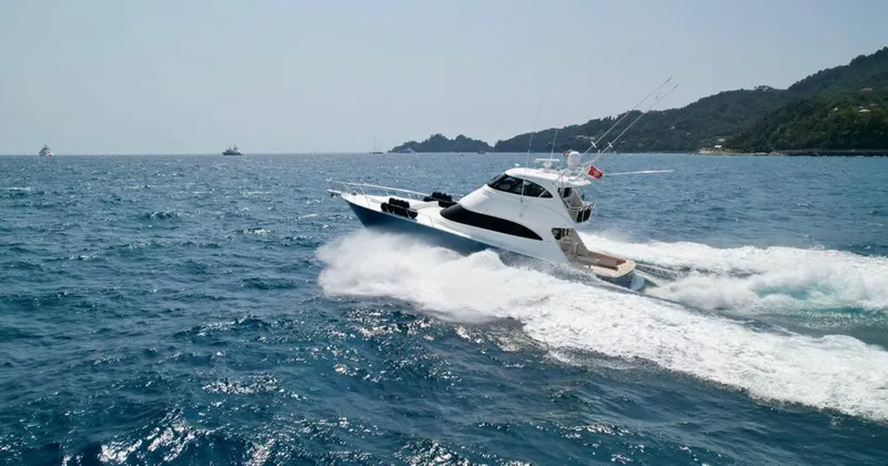 Slide: The Image of 2018 Viking 62 Enclosed Bridge yacht cruising on open sea near coastline. - 4