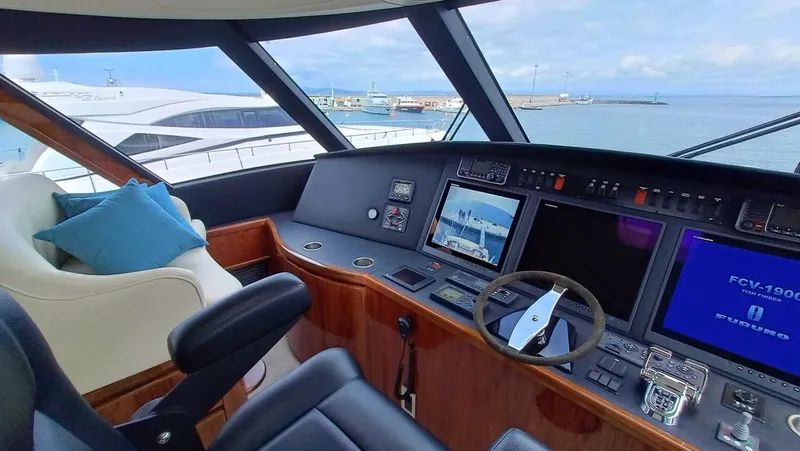 Slide: The Image of 2018 Viking 62 Enclosed Bridge yacht helm with modern navigation systems and luxurious seating. - 40