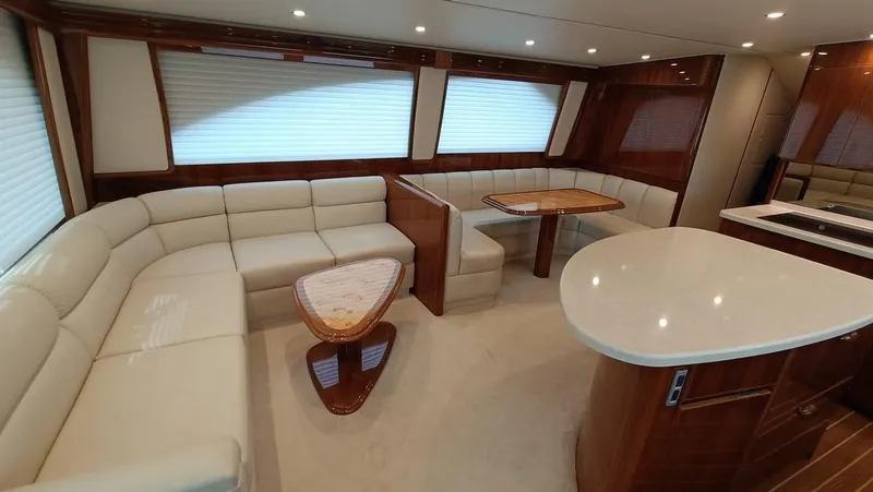Slide: The Image of Luxurious interior of 2018 Viking 62 Enclosed Bridge yacht with elegant seating and dining area. - 43