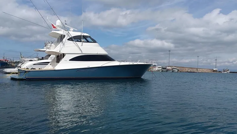 Slide: The Image of 2018 Viking 62 Enclosed Bridge yacht on calm water under cloudy sky. - 45