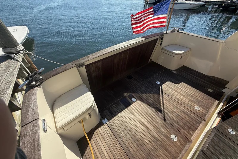 Slide: The Image of 2013 Greenline 33 boat deck with American flag, docked by the water. - 13