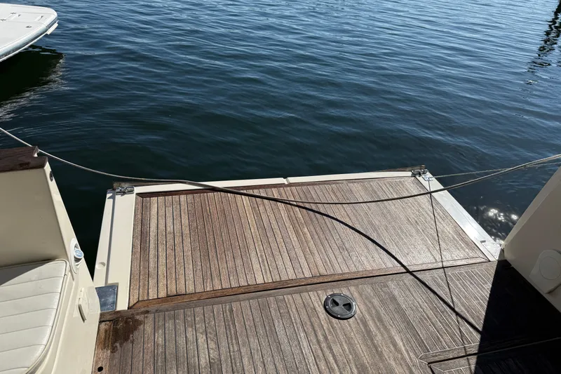 Slide: The Image of 2013 Greenline 33 boat deck with wooden finish, docked on calm water. - 15