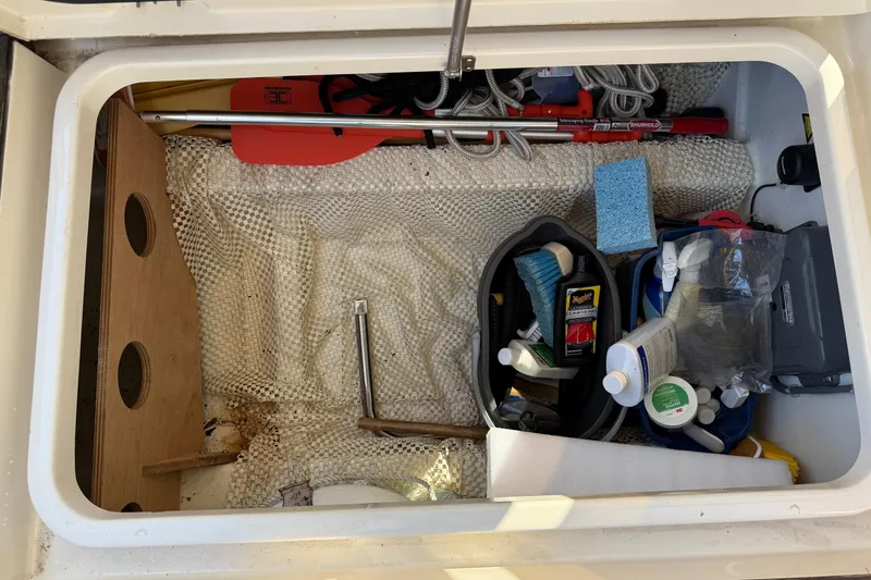 Slide: The Image of Storage compartment on a 2013 Greenline 33 boat with cleaning supplies and tools. - 16