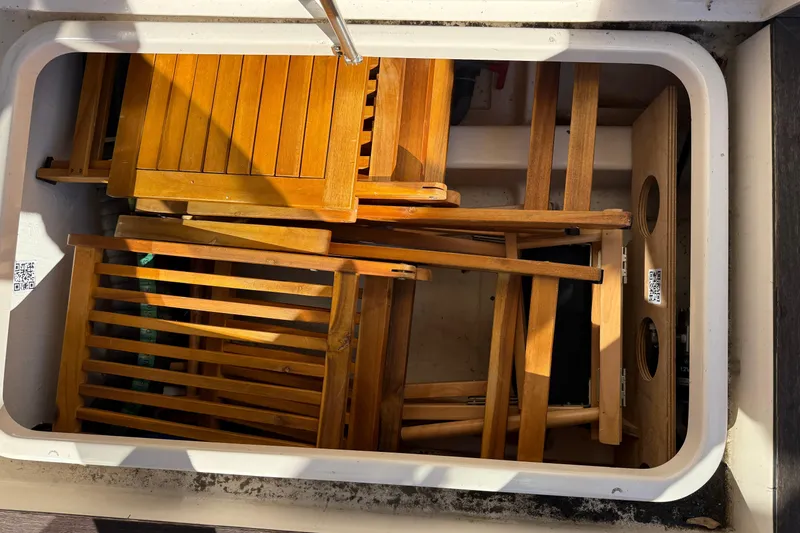 Slide: The Image of Storage compartment on a 2013 Greenline 33 boat with wooden folding chairs. - 17