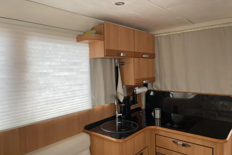 Slide: The Image of Compact kitchen interior of 2013 Greenline 33 boat with wooden cabinets and modern appliances. - 27