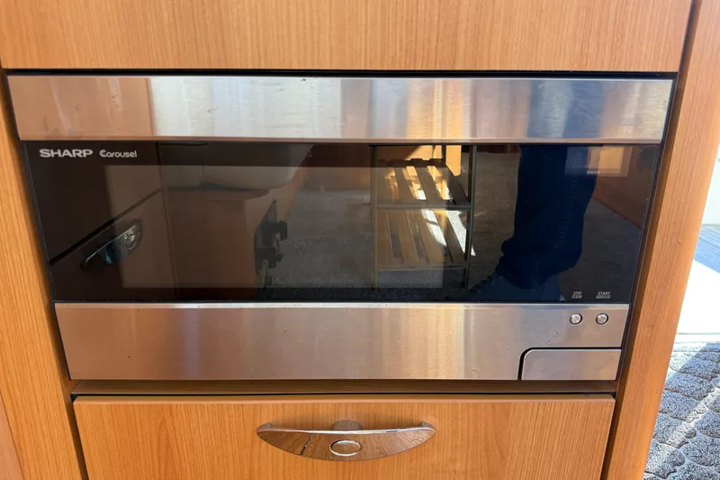 Slide: The Image of Sharp Carousel microwave in a 2013 Greenline 33 interior, featuring a sleek wood finish. - 33