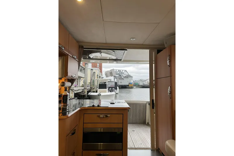 Slide: The Image of Interior view of 2013 Greenline 33 yacht kitchen with marina backdrop. - 39