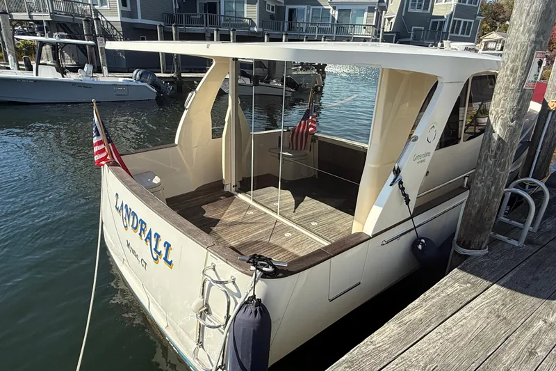 Slide: The Image of 2013 Greenline 33 boat docked, displaying American flags, with "Landfall" name visible. - 4