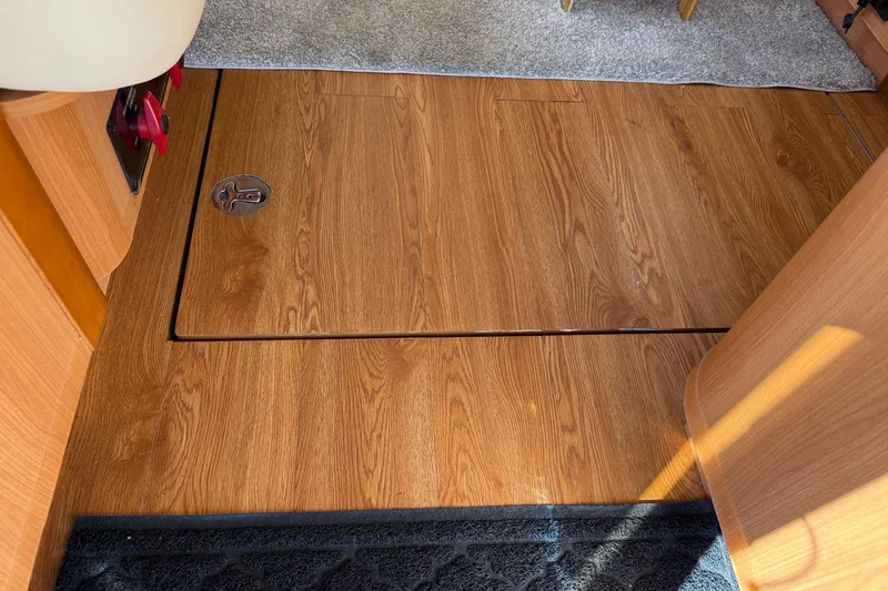 Slide: The Image of Wooden floor inside 2013 Greenline 33 boat, featuring a hatch and carpeted area. - 40