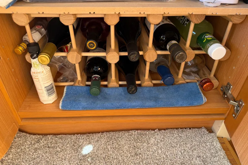 Slide: The Image of Wine rack in a 2013 Greenline 33 boat, stocked with various bottles. - 66