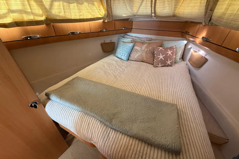 Slide: The Image of Cozy bedroom interior of 2013 Greenline 33 yacht with decorative pillows and wooden cabinets. - 71