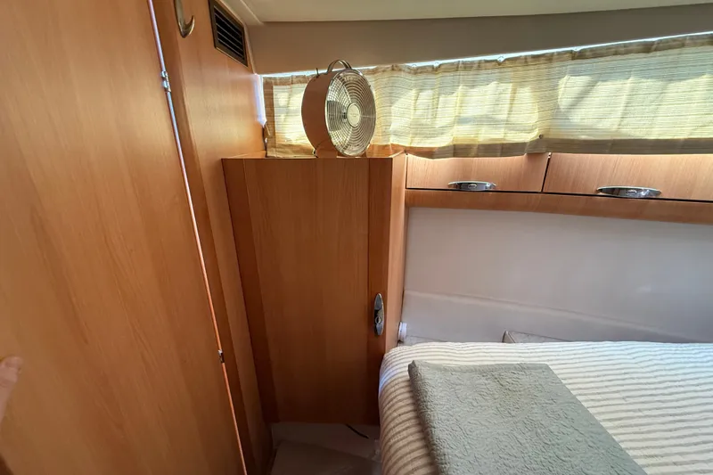 Slide: The Image of Cozy cabin interior of 2013 Greenline 33 yacht with wooden furnishings and a small fan. - 74