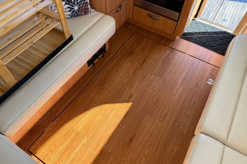 Slide: The Image of Interior of 2013 Greenline 33 yacht with wooden flooring and beige seating. - 86