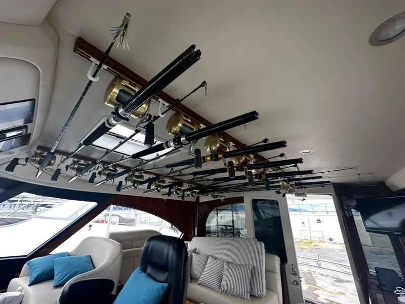 Slide: The Image of 2018 Viking 62 Enclosed Bridge interior with fishing rods on ceiling rack. - 21