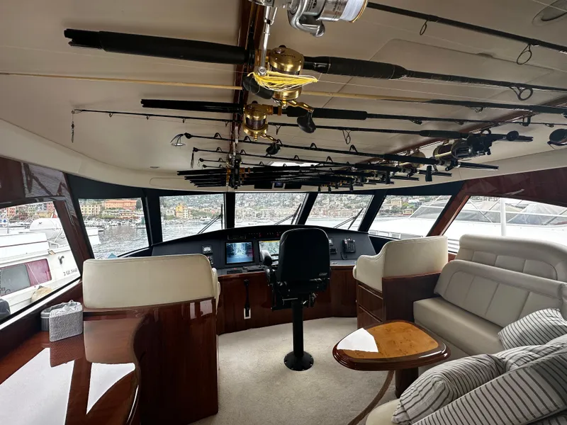 Slide: The Image of 2018 Viking 62 Enclosed Bridge yacht interior with fishing rods and helm station. - 22