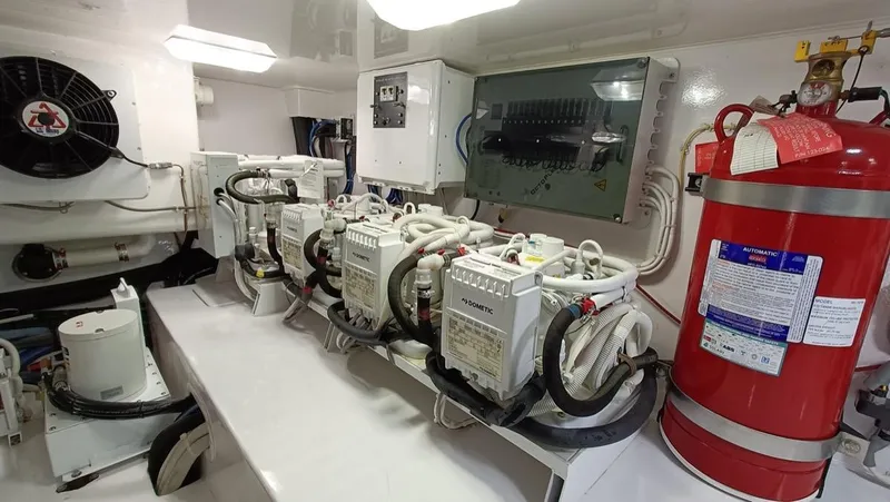 Slide: The Image of Engine room of 2018 Viking 62 Enclosed Bridge yacht with fire extinguisher and machinery. - 27