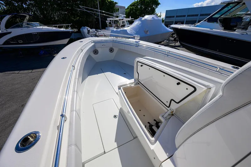 Slide: The Image of 2021 Contender 35 ST boat deck with open storage compartment, docked outdoors. - 14