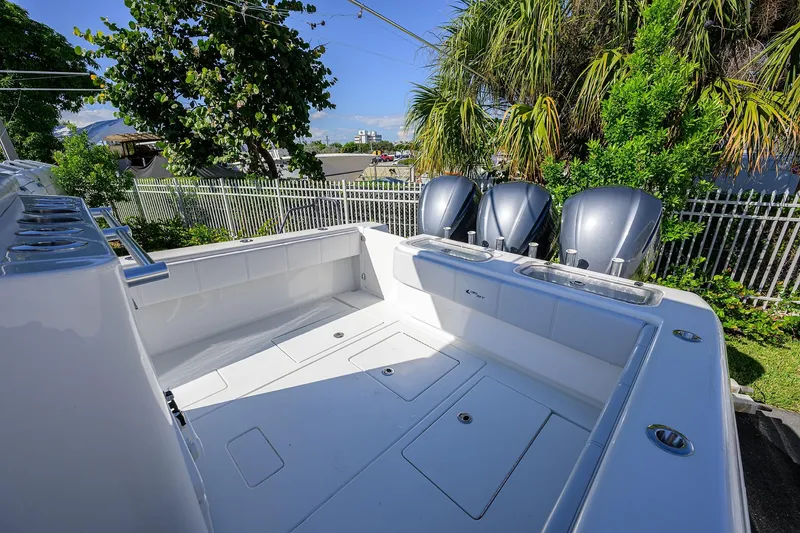 Slide: The Image of 2021 Contender 35 ST boat with triple engines, spacious deck, and lush greenery background. - 25