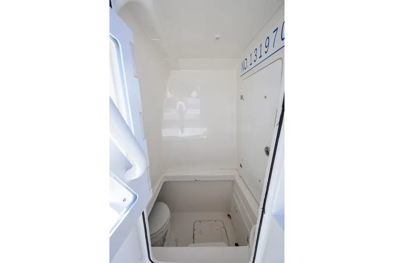 Slide: The Image of Interior of 2021 Contender 35 ST boat, featuring a compact, white marine toilet area. - 36