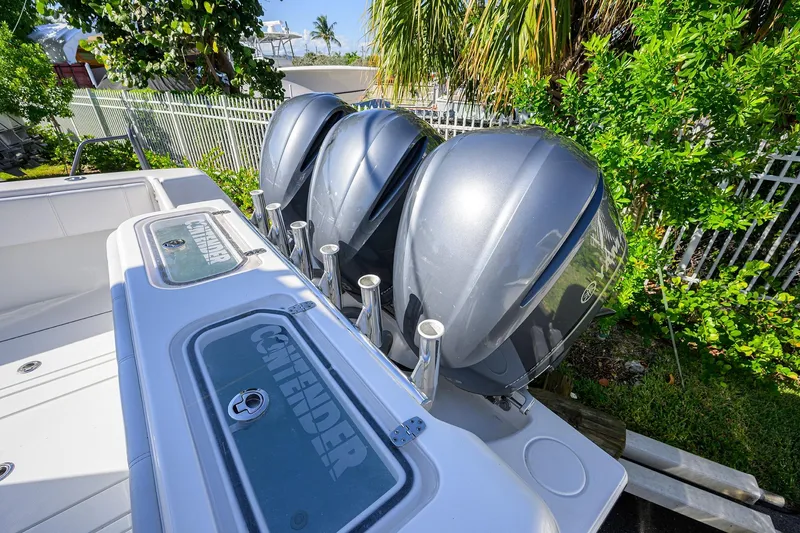 Slide: The Image of 2021 Contender 35 ST boat with triple outboard engines, surrounded by lush greenery. - 43
