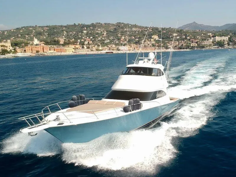 Slide: The Image of 2018 Viking 62 Enclosed Bridge yacht cruising on open water near scenic coastline. - 0