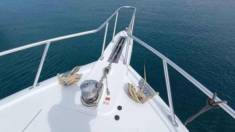 Slide: The Image of Bow of 2018 Viking 62 Enclosed Bridge yacht with anchor and railing, on calm water. - 36