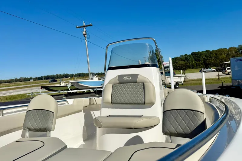 Slide: The Image of 2025 Key West 203 FS boat interior with cushioned seating and console, under clear blue sky. - 19
