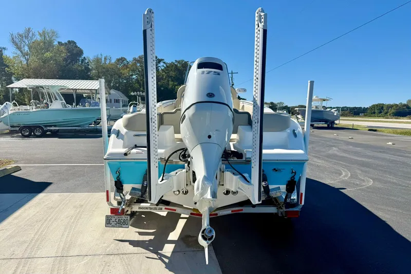 Slide: The Image of 2025 Key West 203 FS boat with outboard motor on trailer in parking lot. - 2