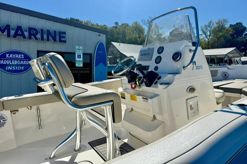 Slide: The Image of 2025 Key West 203 FS boat interior with helm and seating, displayed at a marine store. - 26