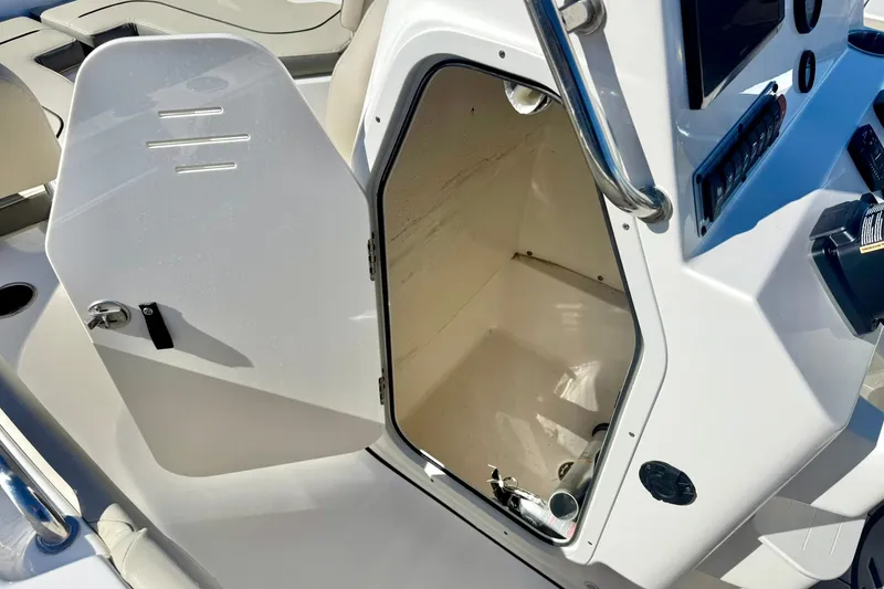 Slide: The Image of 2025 Key West 203 FS boat interior with open storage compartment and control panel. - 28