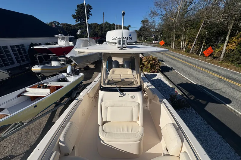Slide: The Image of 2017 Grady-White Fisherman 257 boat on display near a road, surrounded by other boats. - 9