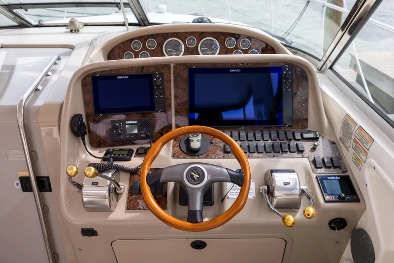 Slide: The Image of Cockpit of 2000 Sea Ray 370 Express Cruiser with navigation equipment and wooden steering wheel. - 11