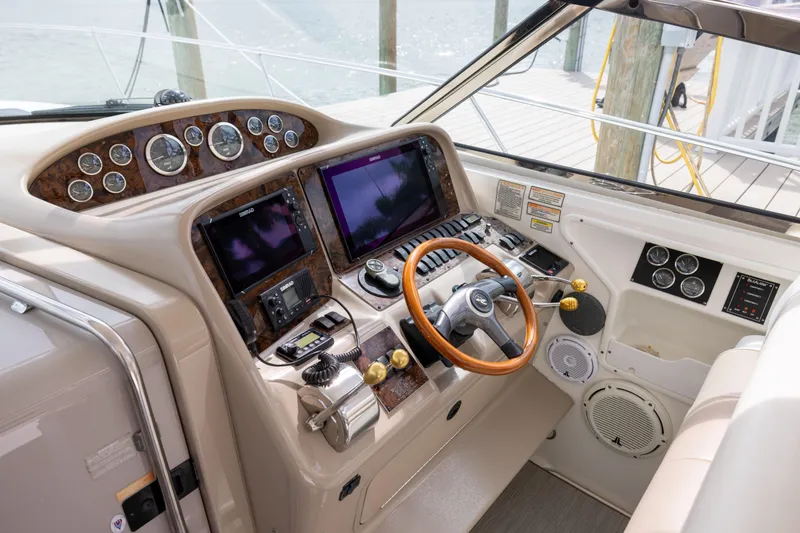 Slide: The Image of Cockpit of 2000 Sea Ray 370 Express Cruiser with advanced navigation controls and wooden steering wheel. - 12