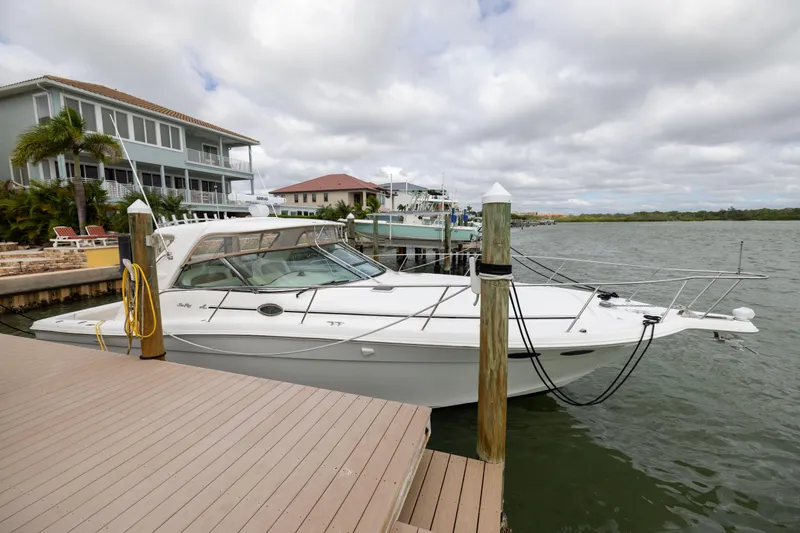 Slide: The Image of 2000 Sea Ray 370 Express Cruiser docked by waterfront homes. - 16