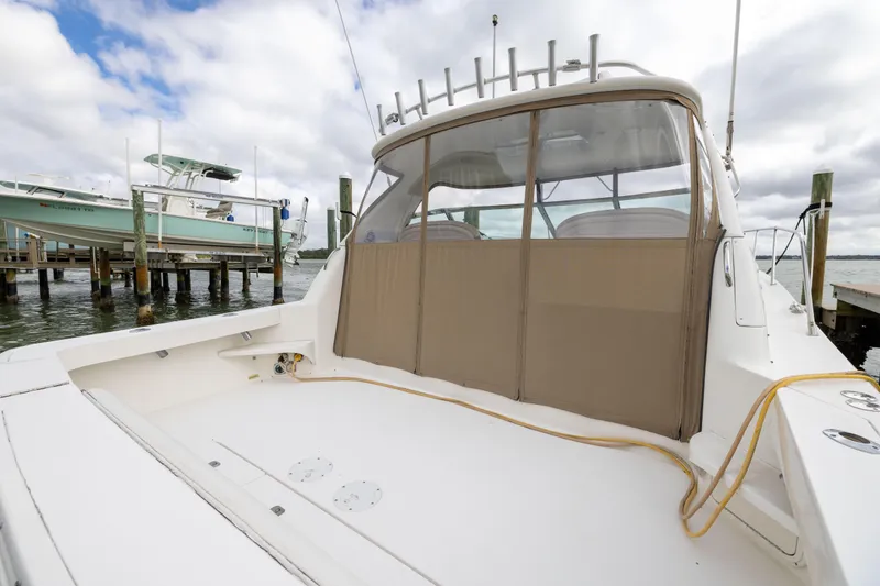 Slide: The Image of 2000 Sea Ray 370 Express Cruiser docked, showcasing spacious deck and covered cockpit area. - 19