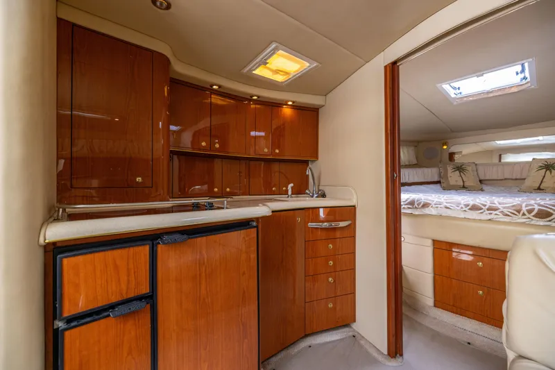Slide: The Image of Interior of 2000 Sea Ray 370 Express Cruiser with wood cabinetry and cozy sleeping area. - 31
