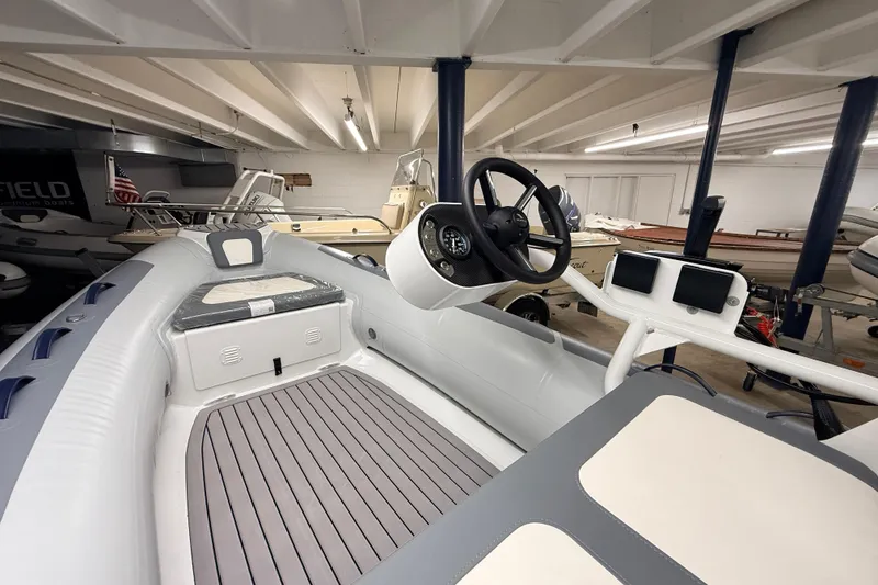 Slide: The Image of 2025 Highfield Classic 400 boat interior with steering wheel and seating in showroom. - 12