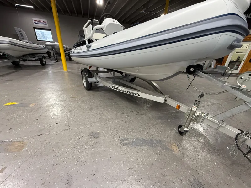 Slide: The Image of 2025 Highfield Classic 400 boat on trailer in showroom. - 2