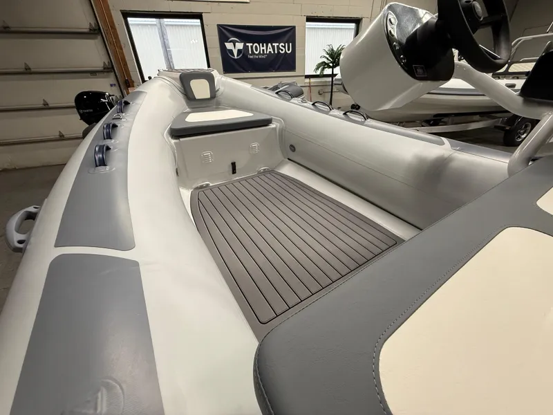 Slide: The Image of 2025 Highfield Classic 400 boat interior with Tohatsu branding, featuring sleek seating and flooring. - 9