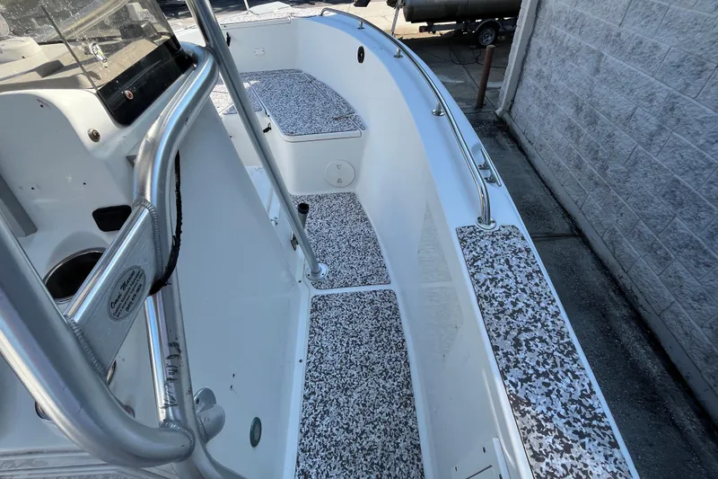 Slide: The Image of 2010 Sea Hunt Triton 220 boat interior with speckled flooring and stainless steel railings. - 12