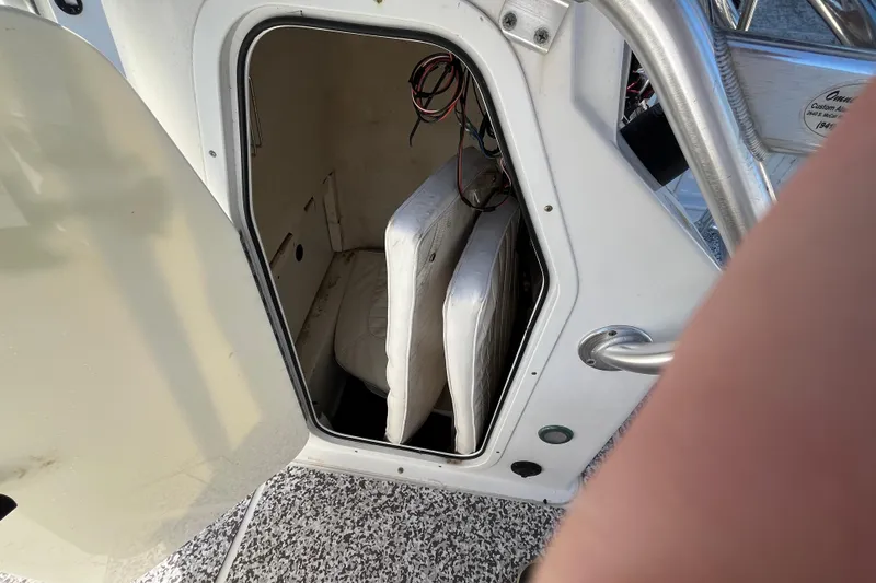Slide: The Image of Open storage compartment on 2010 Sea Hunt Triton 220 boat, showing interior cushions and wiring. - 15